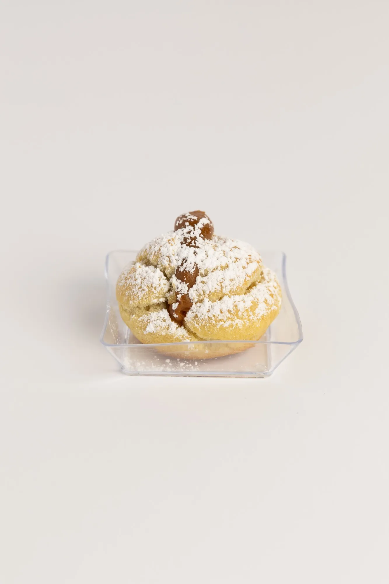 A cream puff dusted with powdered sugar