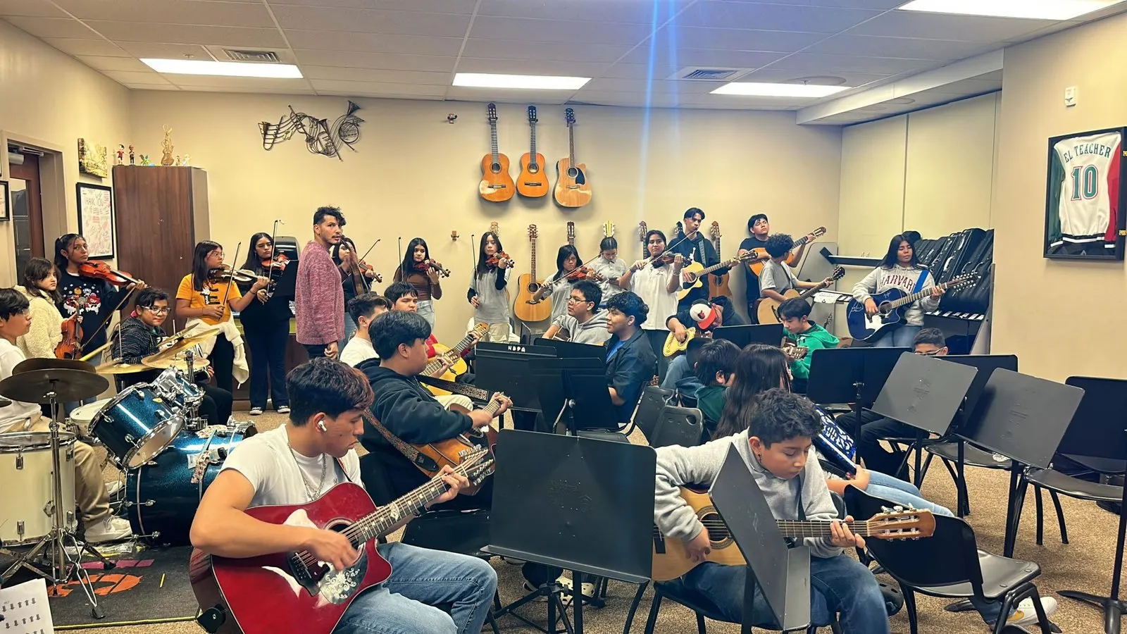 A full ensemble rehearsal with guitars, violins, and drums