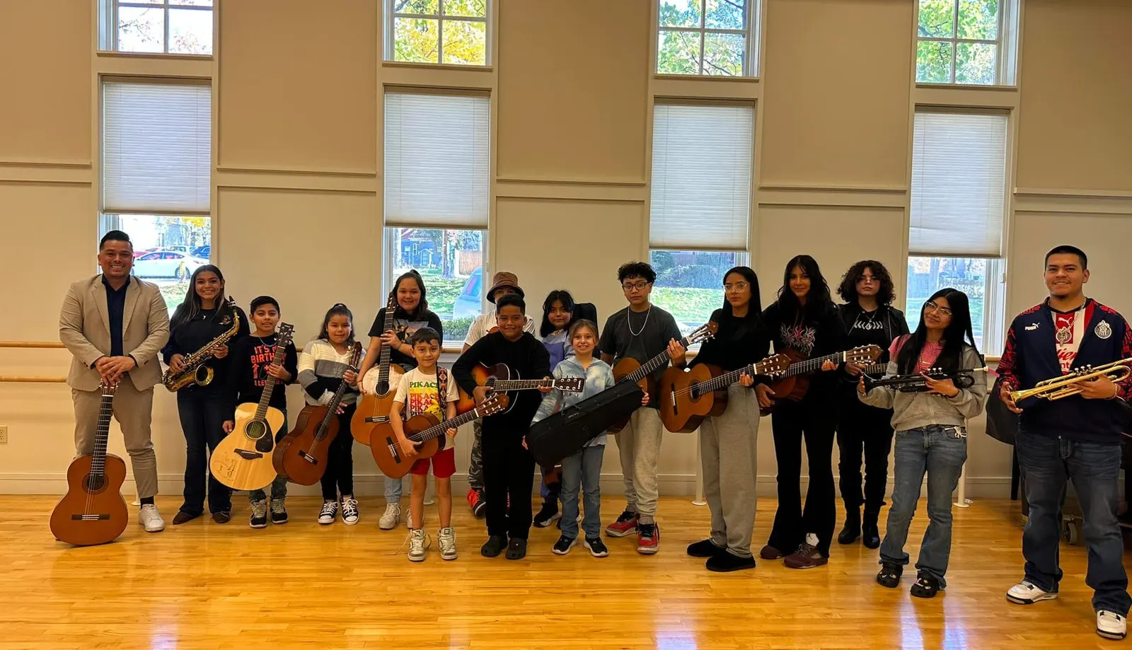 Students holding their guitars with their teachers