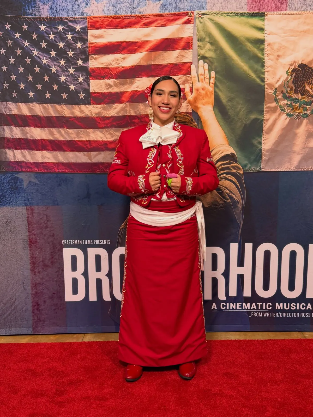 An Academia Mis Raíces mariachi in a red embroidered traje on the red carpet