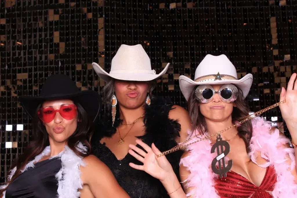 Guests with feather boas, cowboy hats, and sunglasses