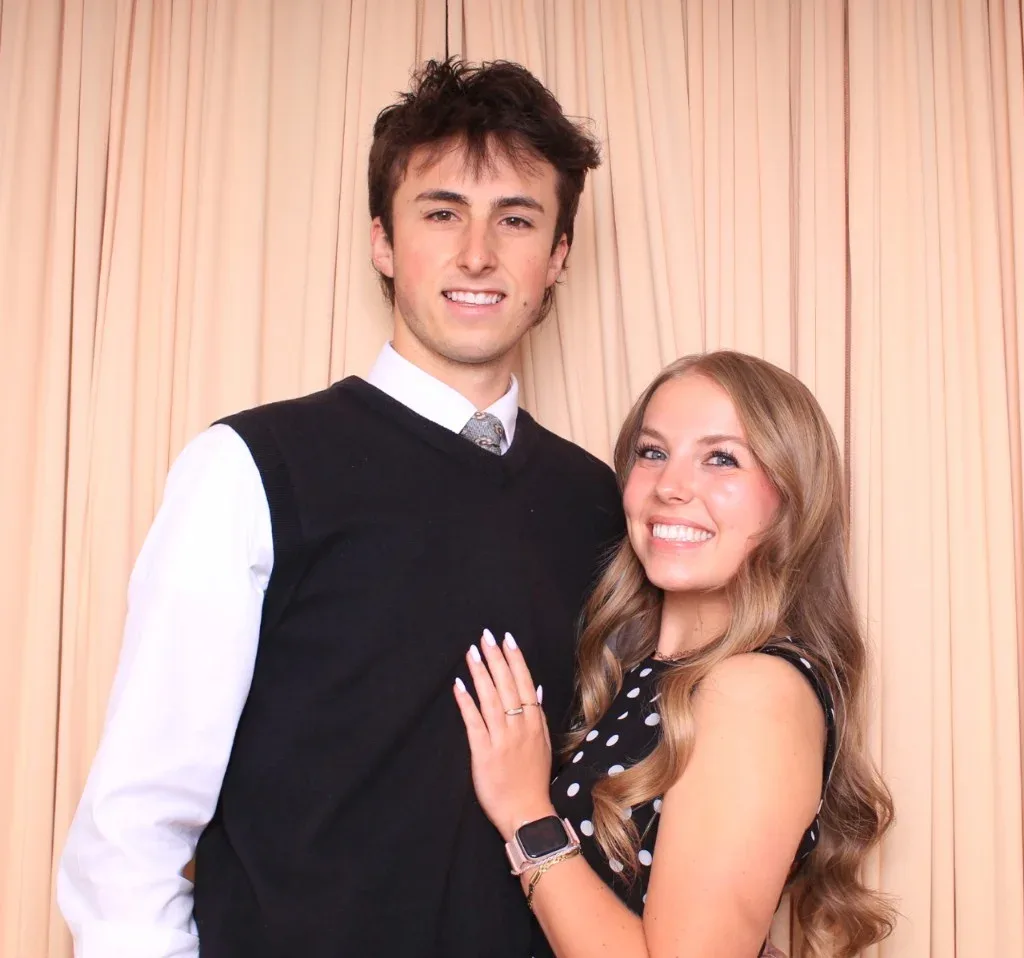 A young couple in front of a peach pleated backdrop