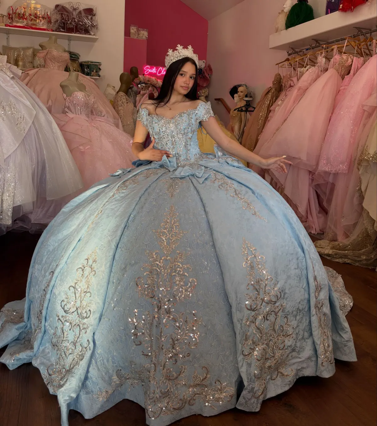 Quinceañera in a powder-blue brocade gown inside the shop