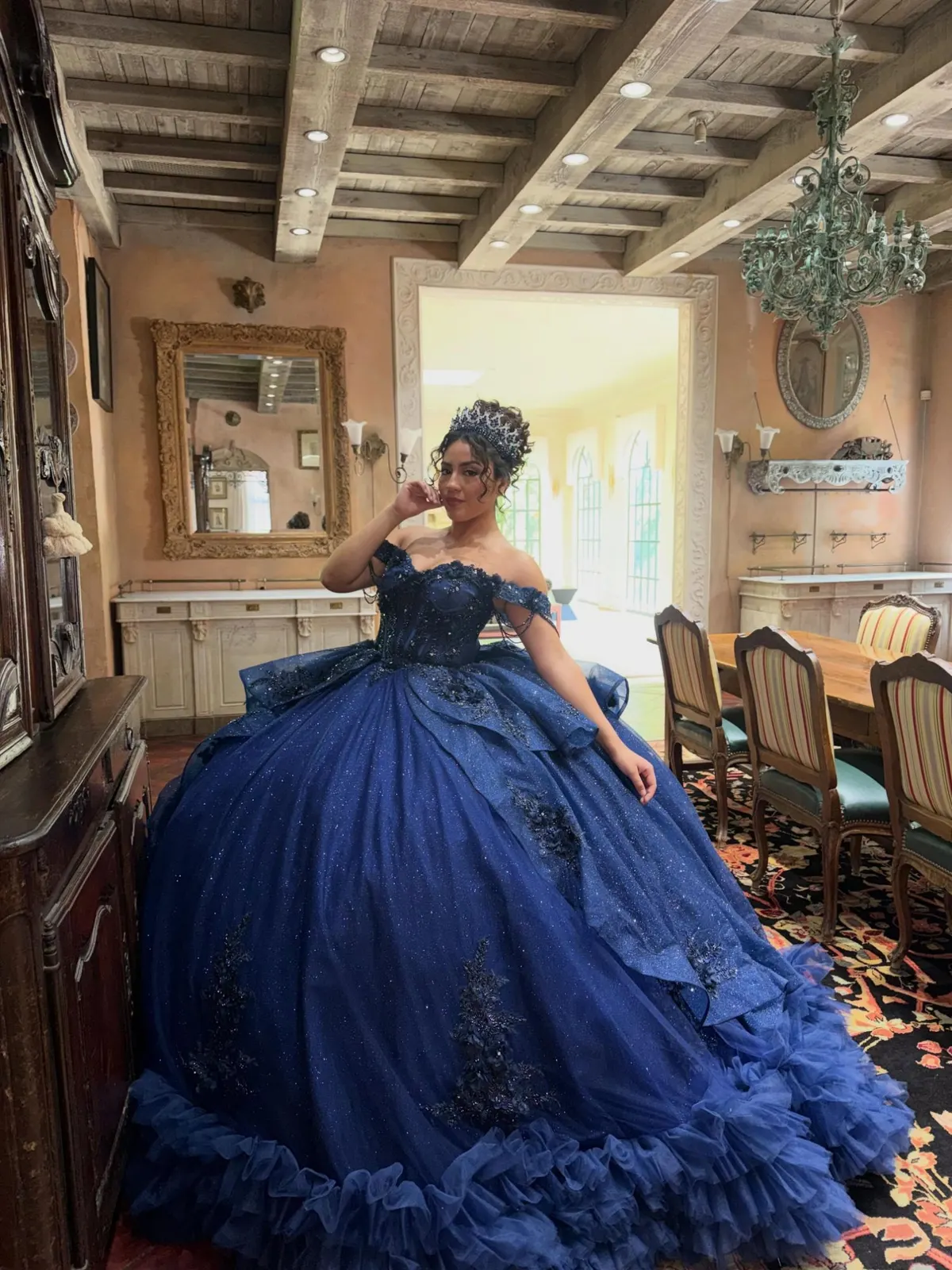 Quinceañera in a glittering navy gown with a crown