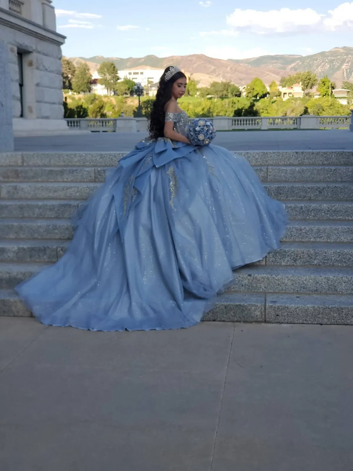 Sky blue quinceañera gown with a long train on the steps of the Utah State Capitol