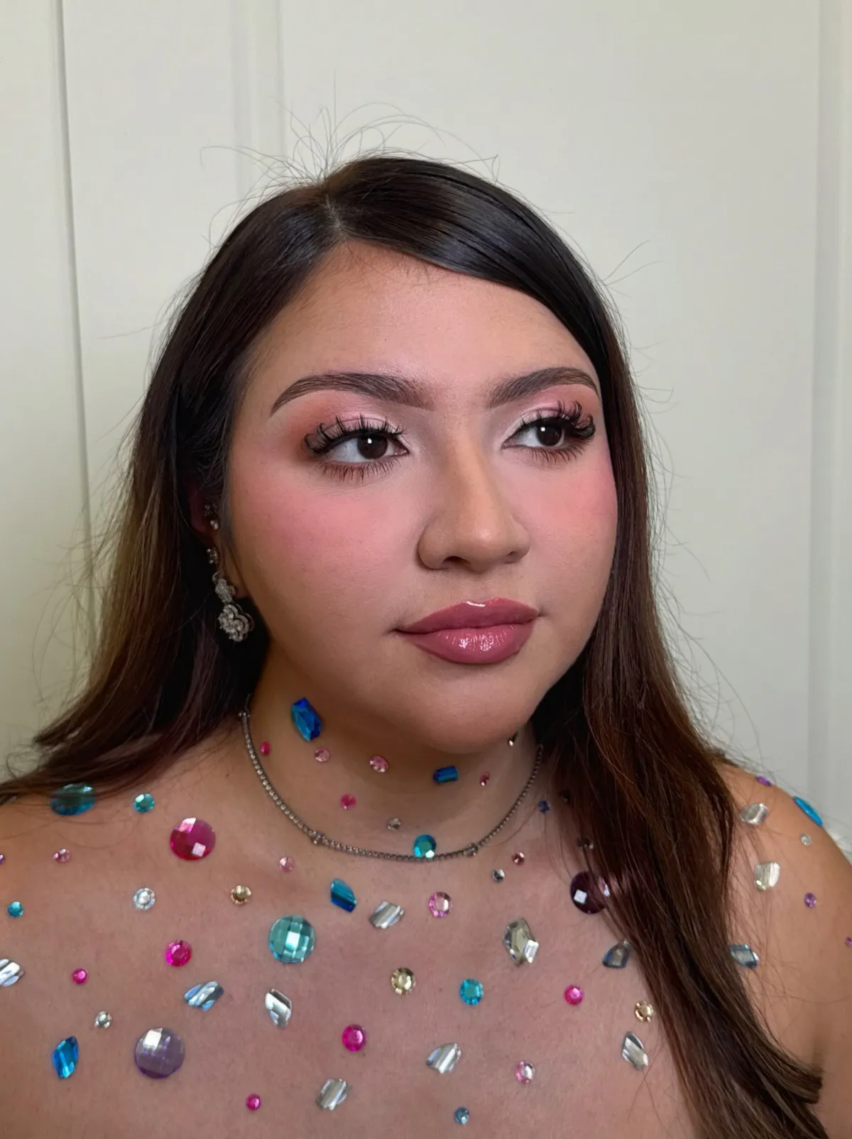A soft pink glam look with rhinestone gems on the neck and shoulders