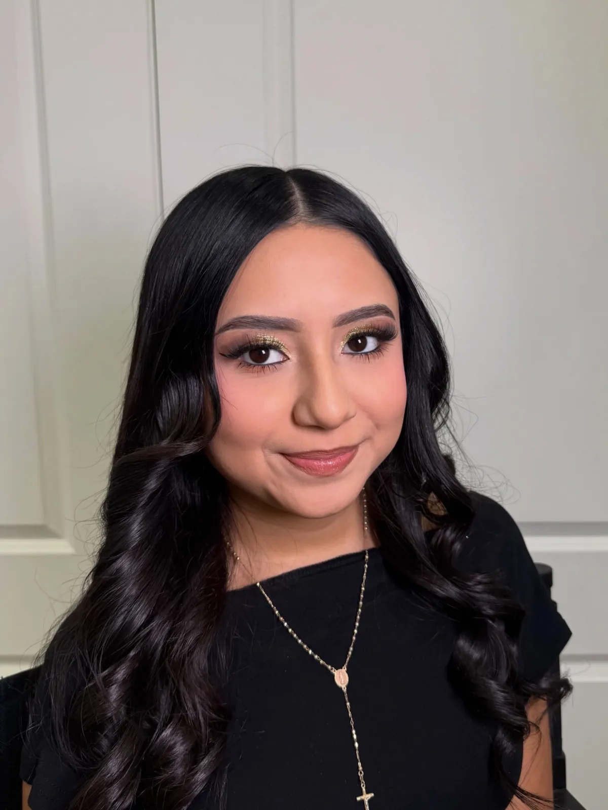 A client with gold glitter eyeshadow and soft waves by Steph X Makeupz