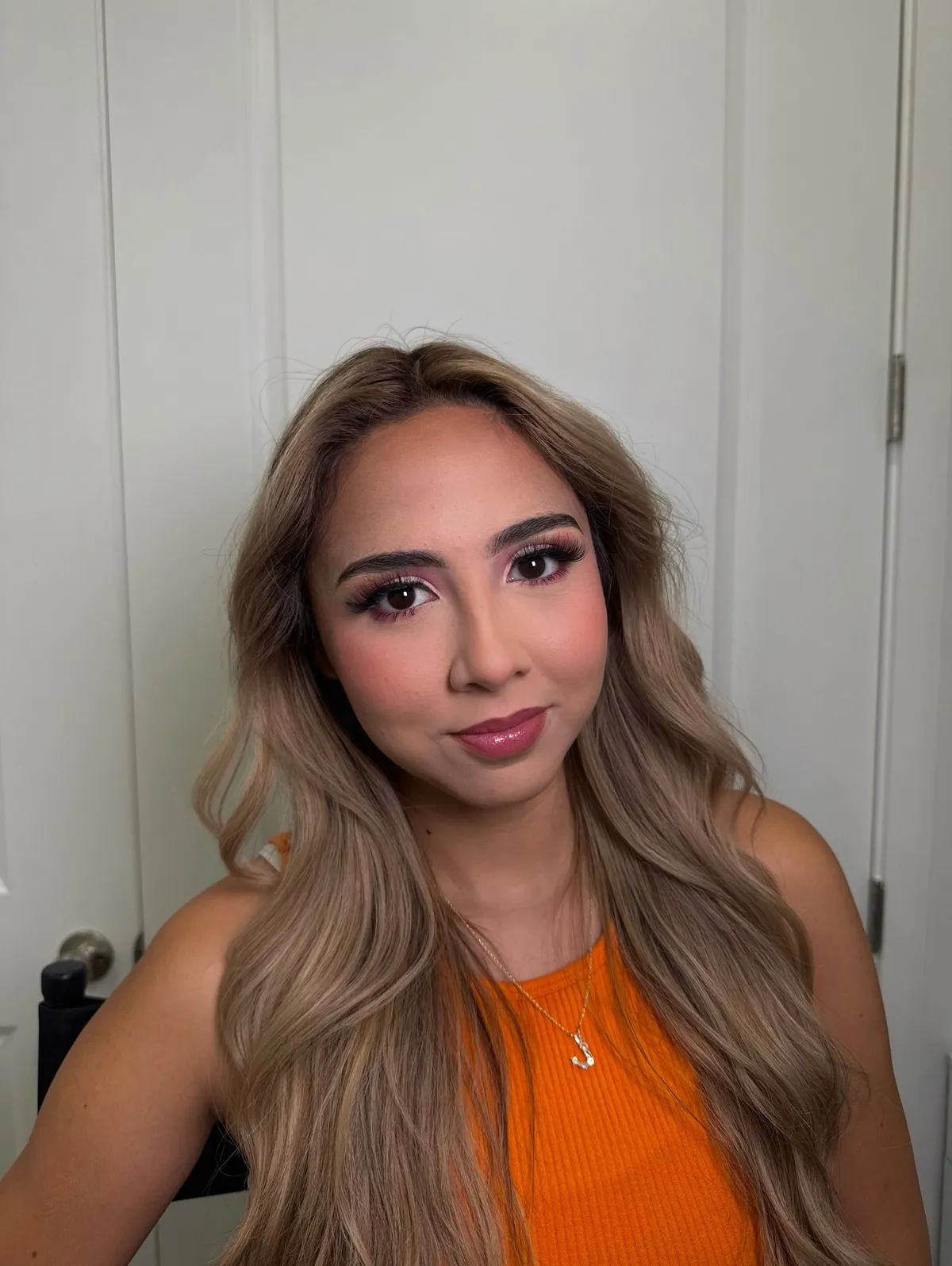A client with a pink and orange eye look and glossy lips